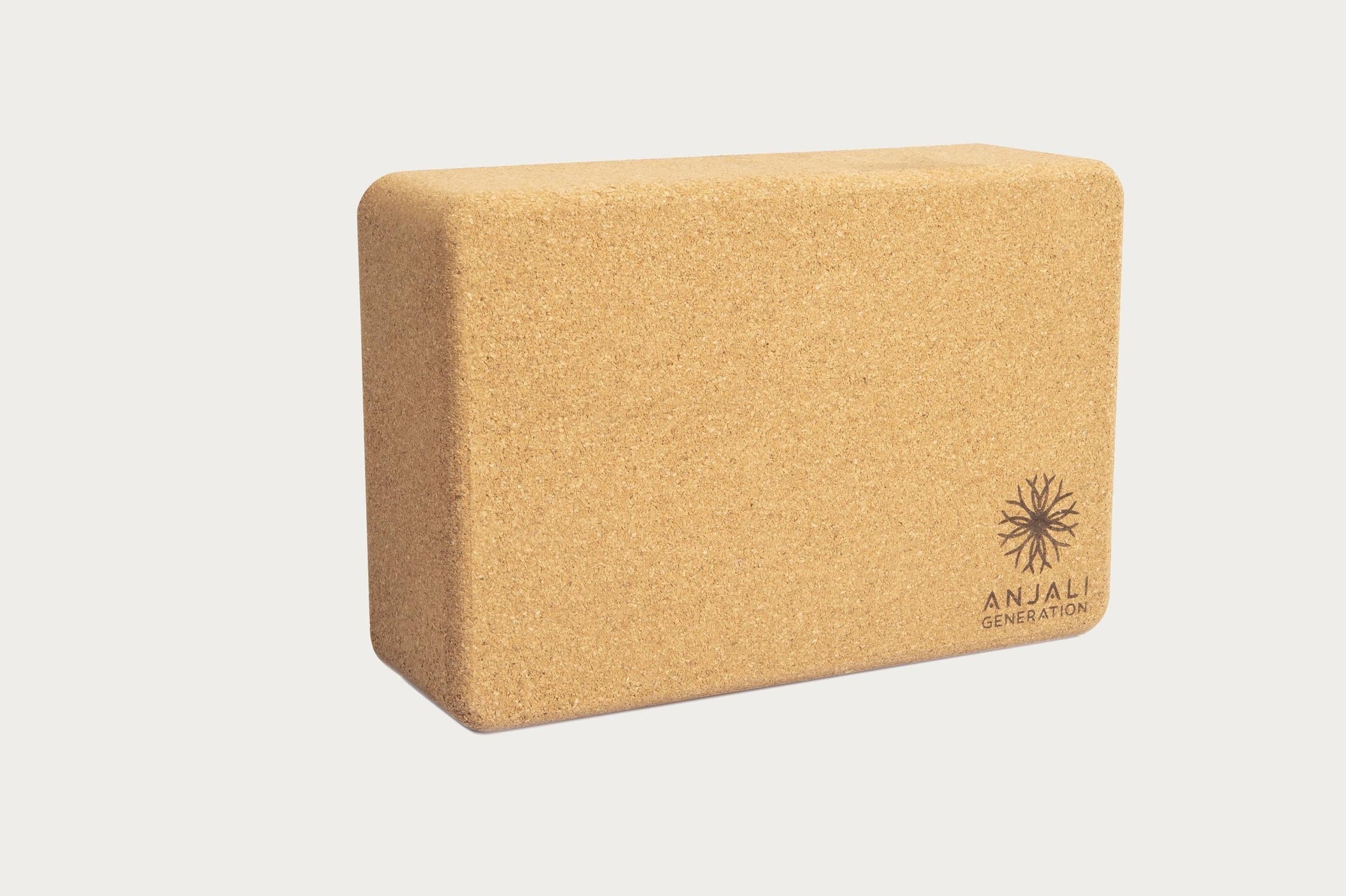 Cork yoga block with 'Anjali Generation' branding on a light gray background