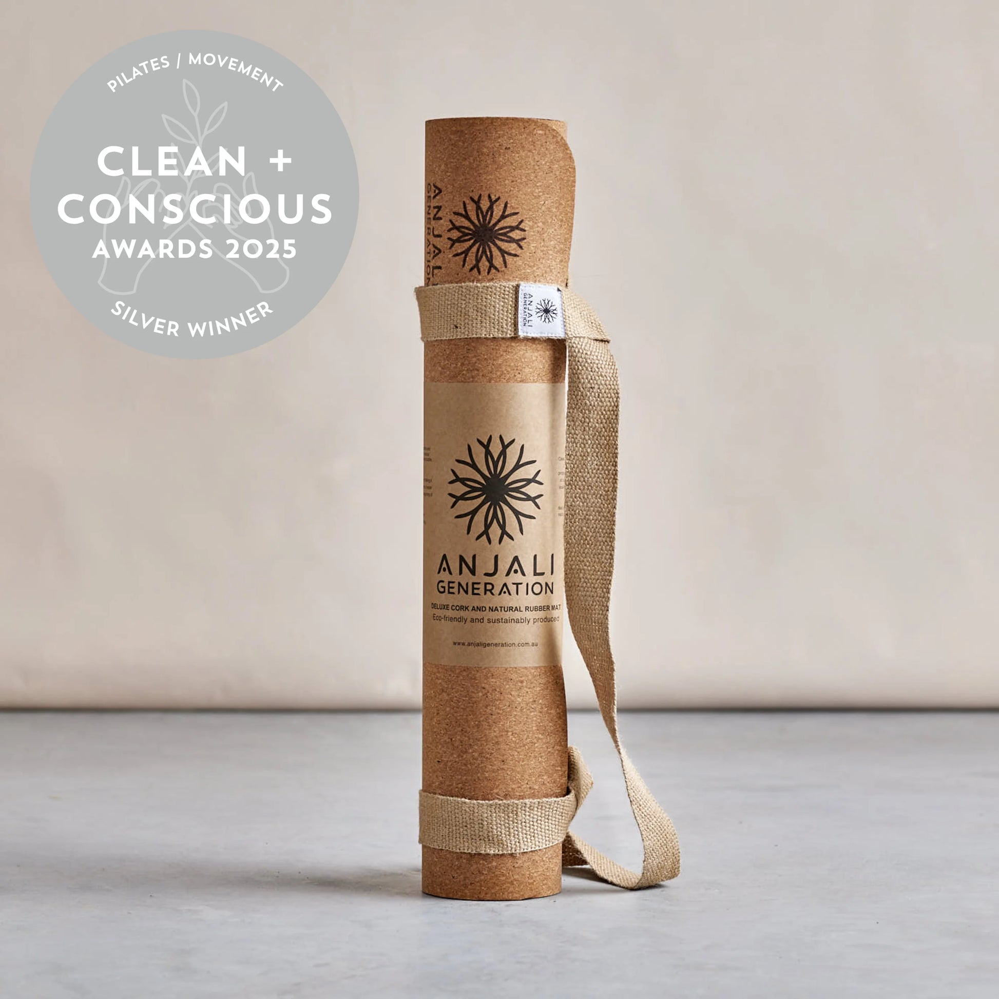 Yoga mat with carrying strap on a light background, featuring the Anjali Generation brand and clean and conscious award.