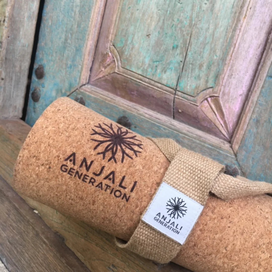 Cork yoga mat with Anjali Generation branding on a wooden surface.