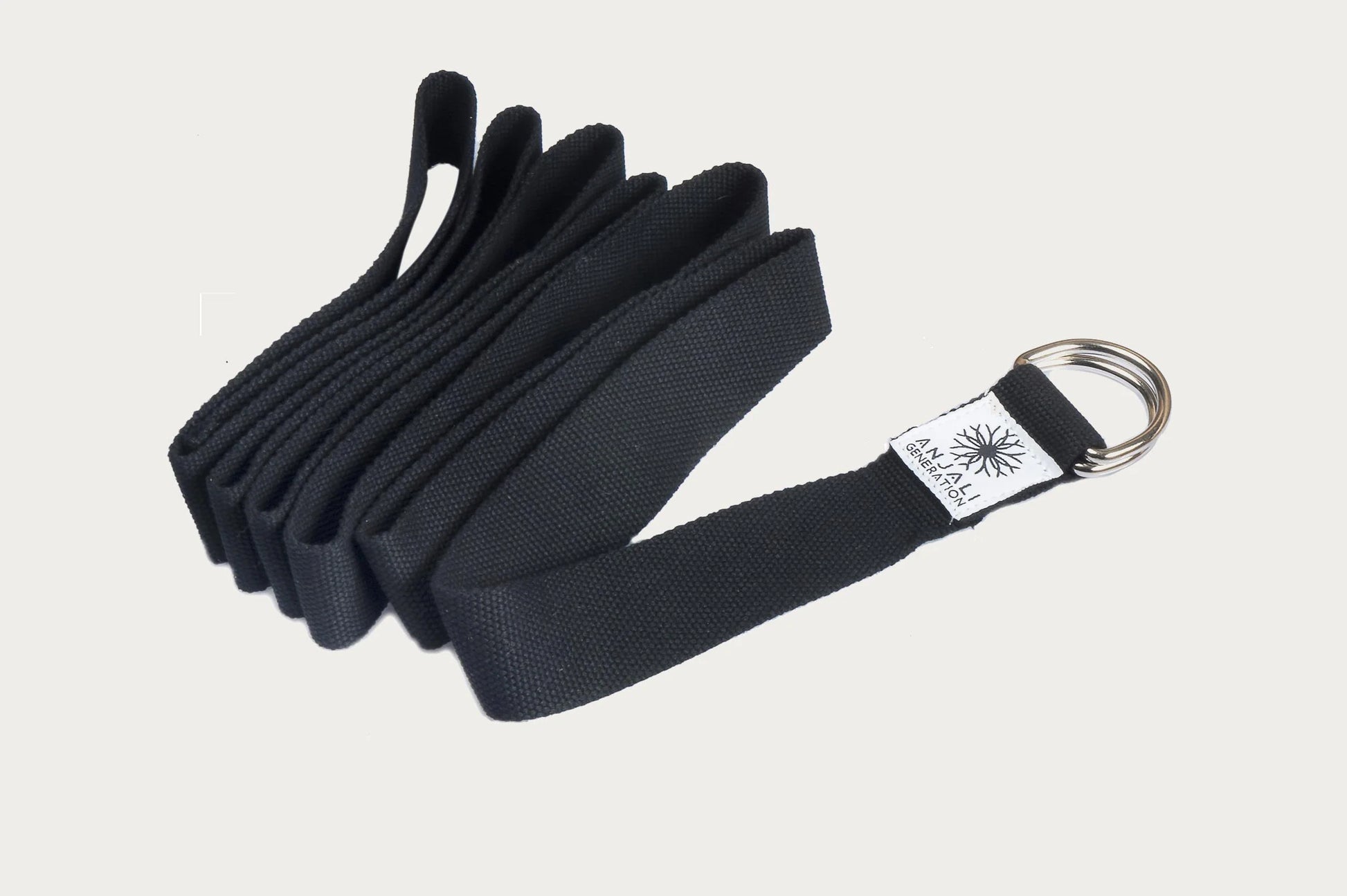 Black yoga strap with a brand logo 'Anjali Generation' on a light gray background
