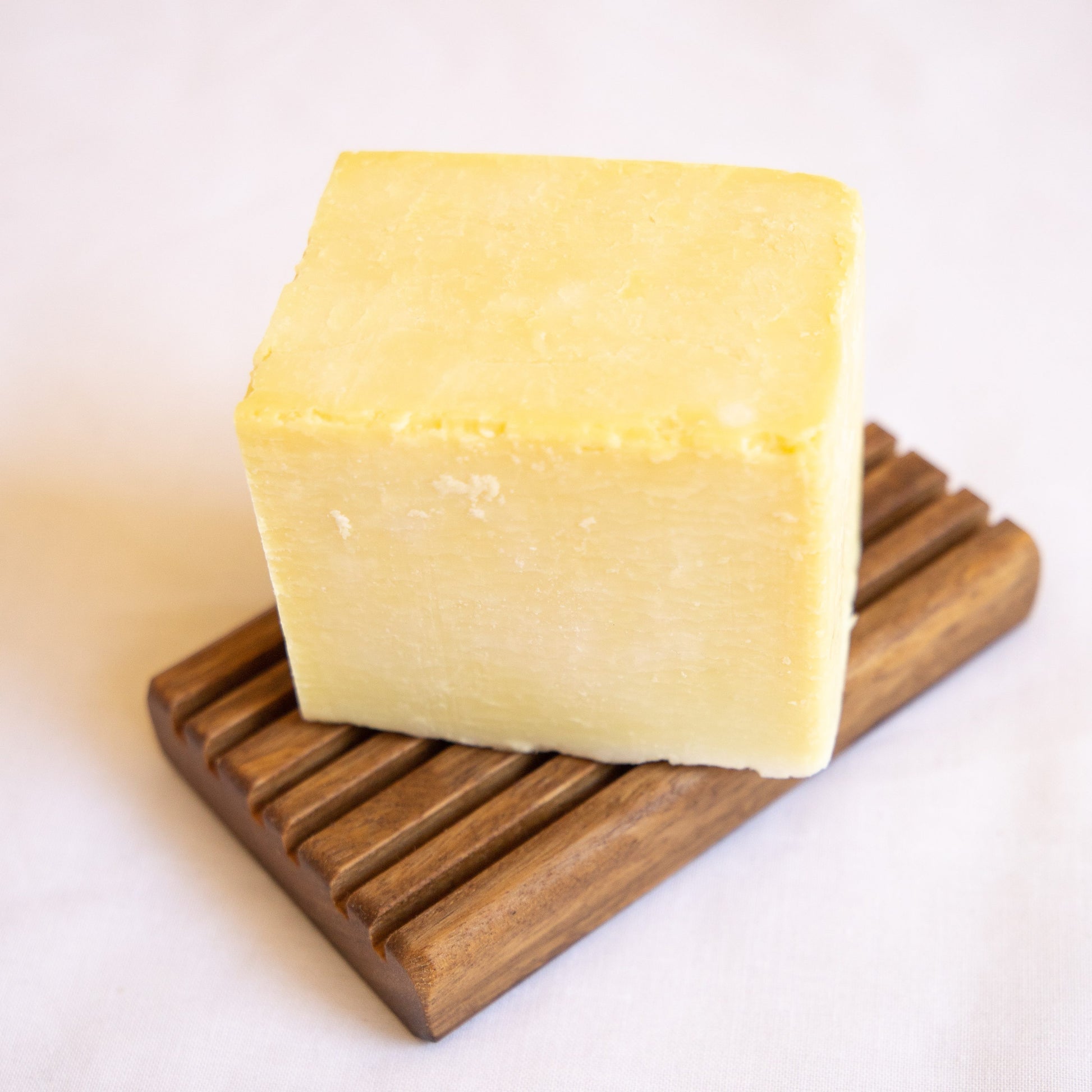Block of Australian Natural Soap Company Dish Soap on a wooden soap rest with a white background