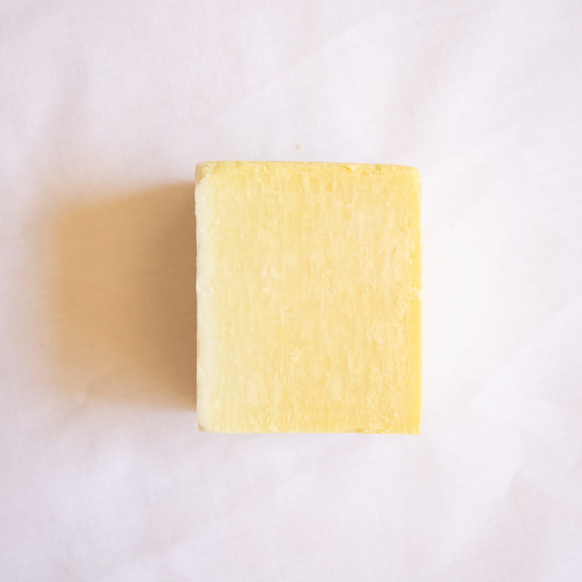 Australian Natural Soap Company yellow dish soap bar on a white background