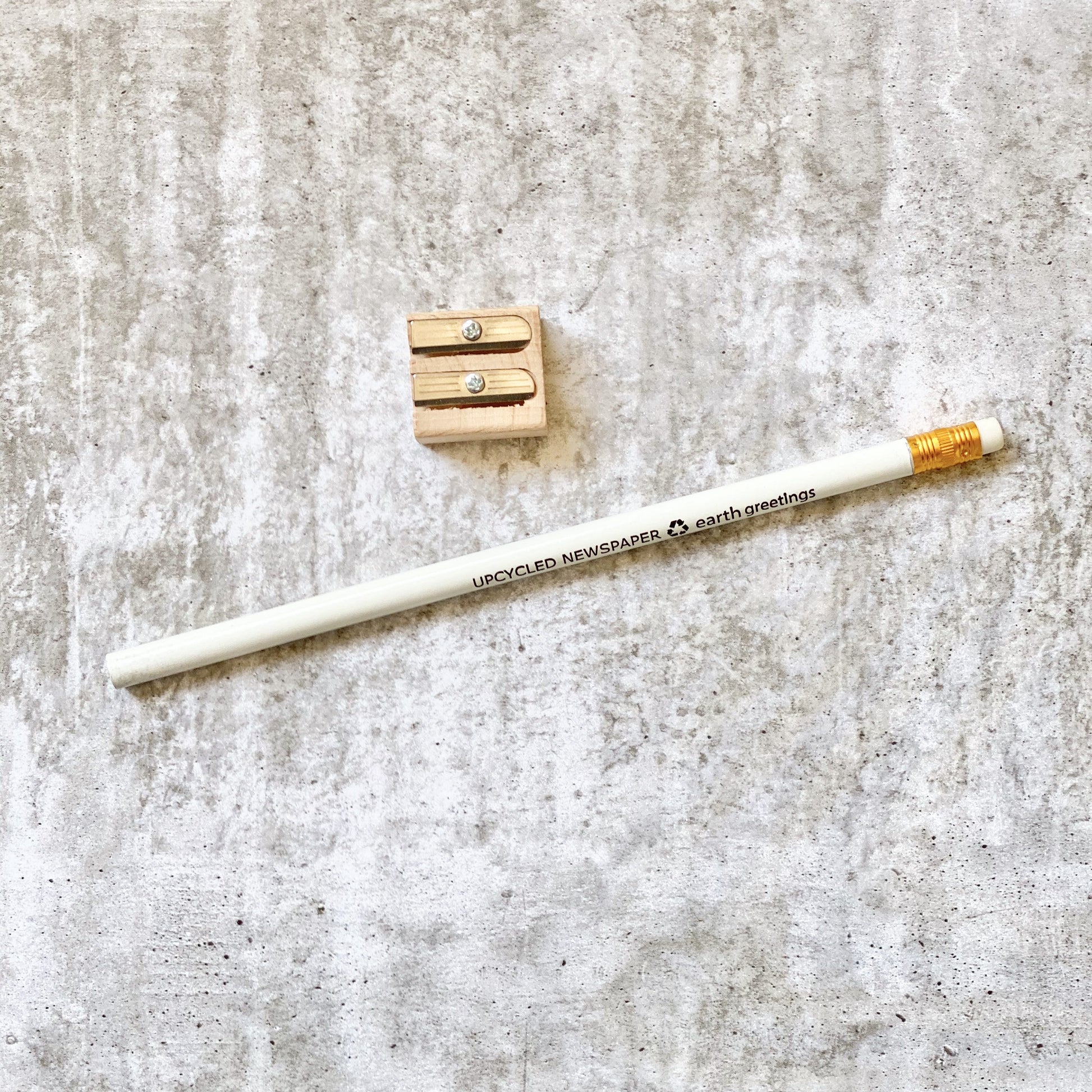 Earth Greetings recycled newspaper pencil and sharpener on a textured surface
