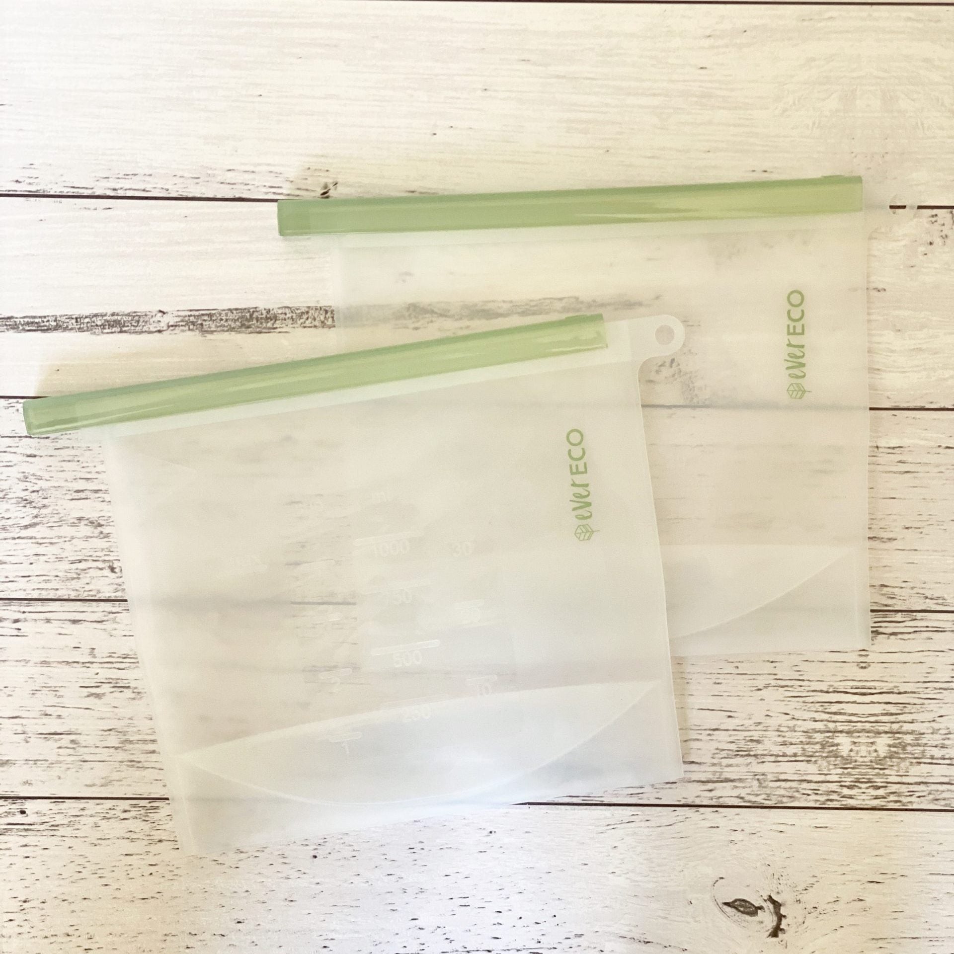 Two 1L Ever Eco Reusable Silicone Food Pouches with green zippers on a wooden surface