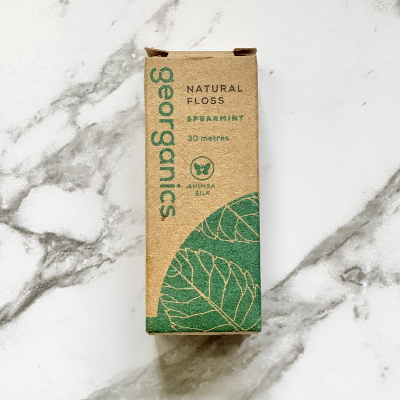 Georganics natural spearmint floss packaging on a marble background