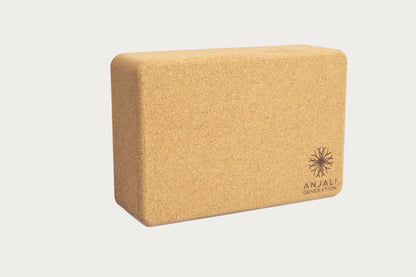 Cork yoga block with 'Anjali Generation' branding on a light gray background