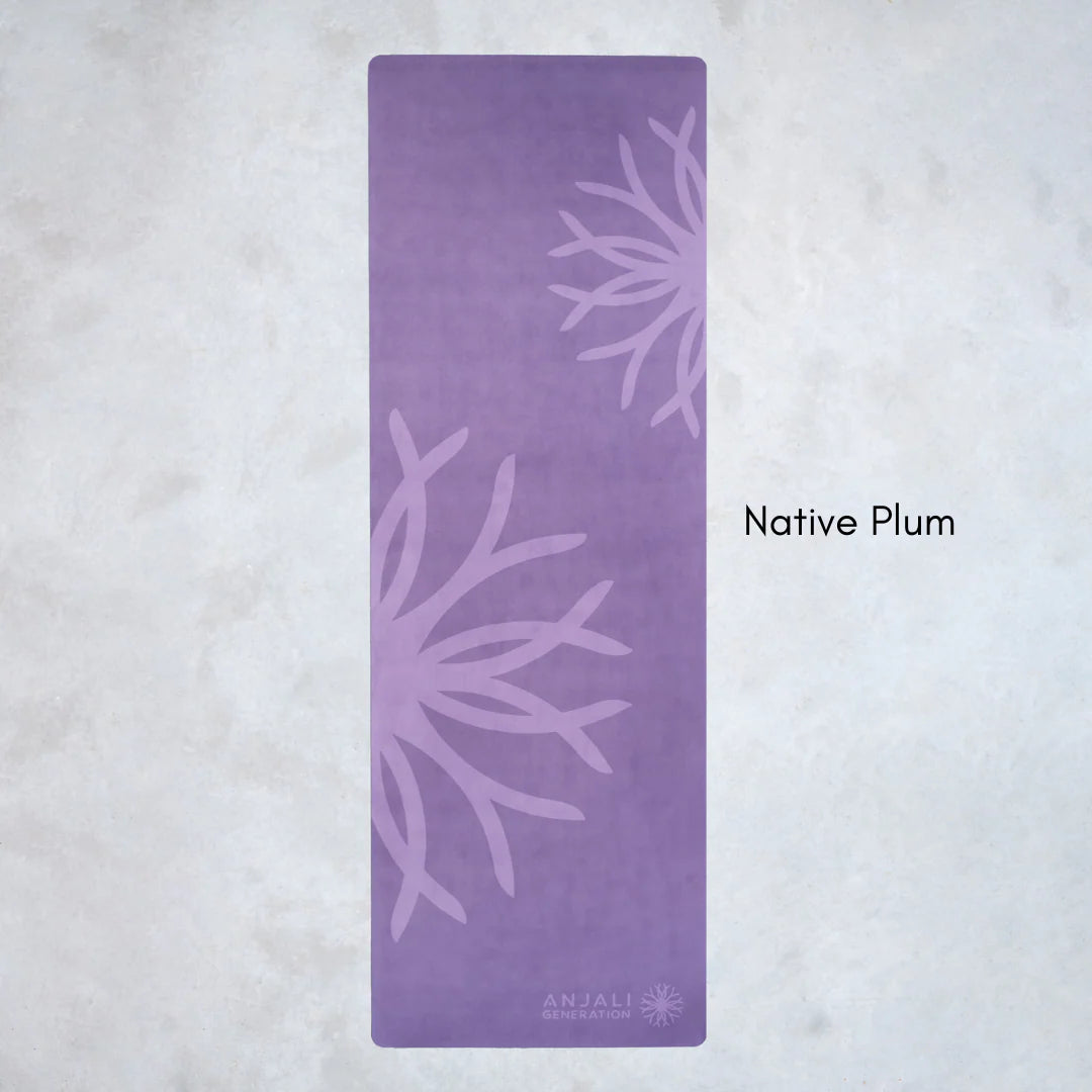 Purple Anjali Generation eco suede yoga mat with floral patterns on a light gray background