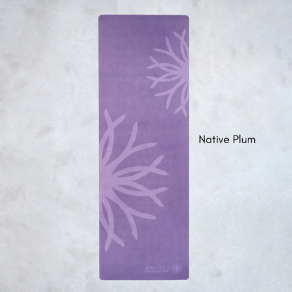 Purple Anjali Generation eco suede yoga mat with floral patterns on a light gray background