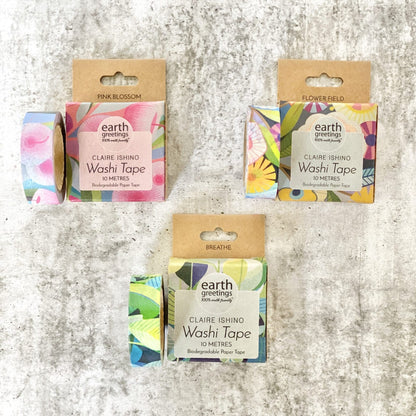 Three rolls of Earth Greetings Claire Ishing Washi Tape with colorful designs on a textured surface