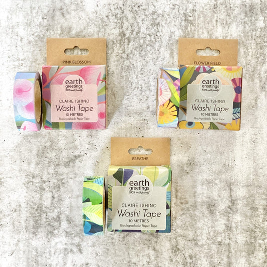 Three rolls of Earth Greetings Claire Ishing Washi Tape with colorful designs on a textured surface