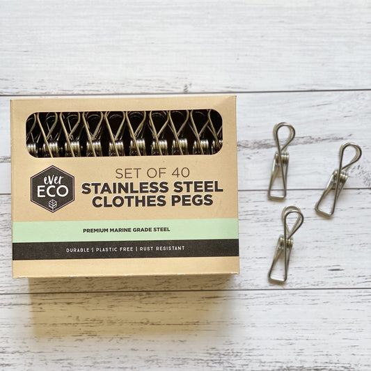 Set of 40 Ever Eco stainless steel clothes pegs with recyclable packaging on a wooden surface