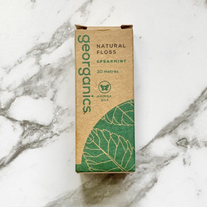Georganics natural spearmint floss packaging on a marble background