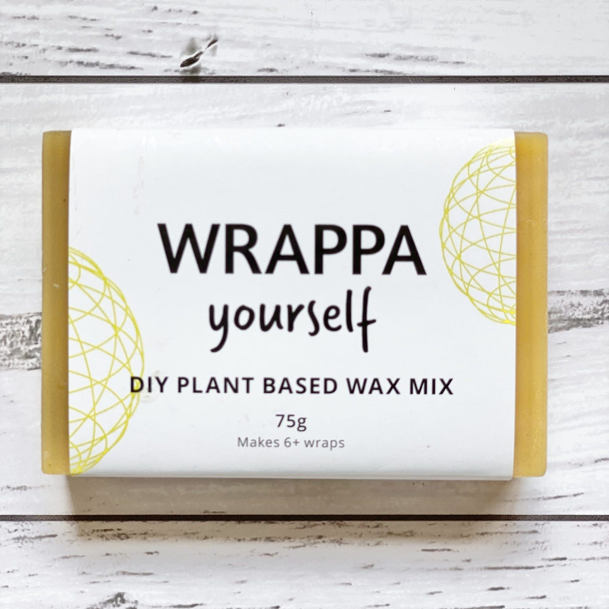 Block of Wrappa plant-based wax for making DIY wax wraps on a wooden surface