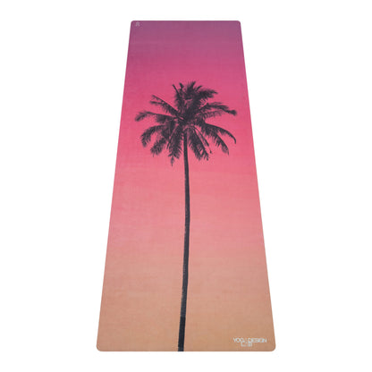 Yoga Design Lab comb mat with a palm tree design and gradient pink to beige color on a white background